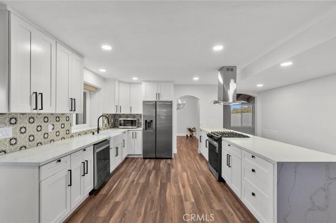 White kitchen remodel with island and stainless appliances